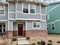 Charming two-story townhouse with gray siding, brick accents, and well-maintained landscaping at 5776 Biscay St, Denver, CO 80249