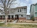 Charming two-story townhouse with gray siding, brick accents, and well-maintained landscaping at 5776 Biscay St, Denver, CO 80249