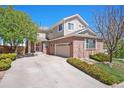 Traditional two-story home with brick facade, two car garage, and a well maintained front yard at 24285 E Wagon Trail Ave, Aurora, CO 80016