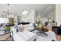 Bright, open-concept living room featuring stylish decor, modern lighting, and seamless flow to the kitchen at 1361 Castlepoint Cir, Castle Pines, CO 80108