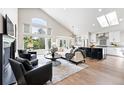 Spacious living room featuring vaulted ceilings, large windows, open layout, and seamless flow to kitchen at 1361 Castlepoint Cir, Castle Pines, CO 80108