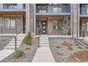 Close up of a townhome entrance with a modern door, concrete steps, and decorative landscaping at 9645 Browns Peak Cir, Littleton, CO 80125
