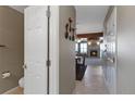Hallway leading to the dining area and living room featuring neutral walls and tile floors at 1847 S Union Blvd, Lakewood, CO 80228