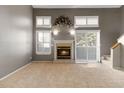 Inviting living room with a fireplace, neutral walls, and abundant natural light from large windows at 1847 S Union Blvd, Lakewood, CO 80228