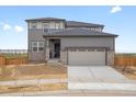 Charming two-story home with a two-car garage, stone accents, and gray siding at 8809 Sedalia St, Commerce City, CO 80022