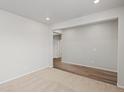 Bright living room with carpet and hardwood floors leading to doorway at 8809 Sedalia St, Commerce City, CO 80022