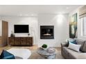 Bright living room with a modern fireplace, stylish furnishings, and hardwood floors at 2314 S University Blvd, Denver, CO 80210