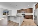 Modern kitchen featuring a large center island with granite countertops, stainless steel appliances, and ample cabinet space at 17836 Gallup St, Broomfield, CO 80023