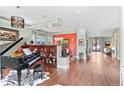 Open-concept living room with hardwood floors, piano, sophisticated decor, and seamless flow to other living spaces at 1344 S Saint Paul St, Denver, CO 80210