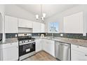 Modern kitchen featuring stainless steel appliances, granite countertops, and bright white cabinets at 3932 S Pagosa St, Aurora, CO 80013