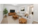 Cozy living room featuring neutral-toned furniture, a wooden entertainment center, and plush carpeting at 3932 S Pagosa St, Aurora, CO 80013