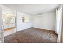 Bright living room features neutral carpet and wall color with open access to the adjacent kitchen at 5372 E 108Th Pl, Thornton, CO 80233