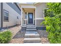 Close-up of front entrance with concrete steps leading up to a cozy, covered porch and inviting front door at 65 Avocet Ct, Longmont, CO 80501