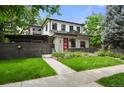 Charming two-story home with stone accents, a red door, and a beautifully landscaped front yard at 2805 S Sherman St, Englewood, CO 80113