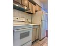 Functional kitchen featuring white appliances, tile backsplash, and light wood cabinets at 7755 E Quincy Ave # 203A6, Denver, CO 80237