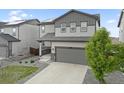 A charming two-story home featuring a two-car garage and a well-maintained lawn with a young tree at 16369 Alberta Dr, Parker, CO 80134