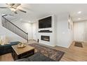 The living room has a modern fireplace, ceiling fan, staircase, and beautiful laminate wood flooring at 16369 Alberta Dr, Parker, CO 80134