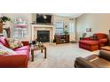 Cozy living room features a fireplace, neutral carpet, and bright windows, creating a welcoming atmosphere at 6792 E Briarwood Dr, Centennial, CO 80112