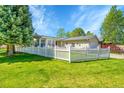 Lovely home with a bright green lawn, a welcoming white picket fence, and mature trees at 7870 Sunflower Green # 151, Frederick, CO 80530