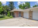 Charming single-story brick home with an attached two-car garage and a well-maintained yard at 100 Dudley St, Lakewood, CO 80226