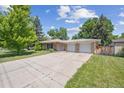 Charming single-story brick home with an attached two-car garage and a long driveway at 100 Dudley St, Lakewood, CO 80226