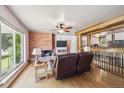 Inviting living room with a brick fireplace, hardwood floors, and a large window with natural light at 100 Dudley St, Lakewood, CO 80226