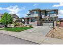 Attractive two-story home with green lawn, two car garage, lush landscaping and a basketball hoop at 22527 E Layton Cir, Aurora, CO 80015