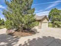 Spacious two-car garage with ample driveway space and mature trees, providing privacy at 5149 Raintree Dr, Parker, CO 80134