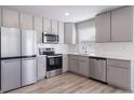 Modern kitchen featuring stainless steel appliances, gray cabinets, and bright countertops at 46570 Avery Ln, Bennett, CO 80102
