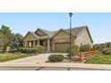 Inviting single-story home featuring a stone and siding exterior, a covered porch, and a well-manicured lawn at 6216 E 135Th Ave, Thornton, CO 80602