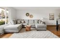 Bright living room featuring a large gray sectional sofa, modern decor, and plush white rug at 117 S Pierce St, Lakewood, CO 80226