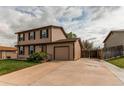 Home exterior featuring a concrete driveway, attached garage, and tidy landscaping at 17882 E Wyoming Pl, Aurora, CO 80017