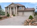 Beautifully landscaped home with a spacious three-car garage and manicured greenery at 3191 Bittersweet Ln, Evergreen, CO 80439