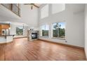 Bright living room boasts soaring ceilings, large windows with mountain views, and a stone fireplace at 3191 Bittersweet Ln, Evergreen, CO 80439