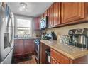 Well-equipped kitchen with wooden cabinets, granite countertops, and stainless steel appliances at 1177 Jamaica St, Aurora, CO 80010