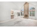Spacious living room with vaulted ceilings and a brick fireplace, connected to the kitchen area at 5485 S Jasper Ct, Centennial, CO 80015