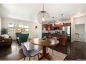Open-concept living room and kitchen with hardwood floors, modern lighting, and stainless steel appliances at 11213 Colony Cir, Broomfield, CO 80021
