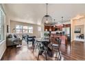 Open-concept living and dining area boasts hardwood floors and modern light fixtures at 11213 Colony Cir, Broomfield, CO 80021