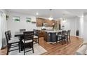 Open concept kitchen features a large island, modern lighting, stainless steel appliances, and hardwood floors at 10152 Xanadu St, Commerce City, CO 80022