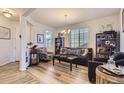 Open living space with a stylish sofa, two chairs, hardwood floors and natural light at 4724 S Wenatchee Cir, Aurora, CO 80015