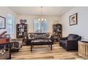Comfortable living room with a large window, hardwood floors, and stylish furniture at 4724 S Wenatchee Cir, Aurora, CO 80015