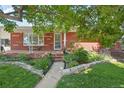 Inviting front porch with brick accents, decorative planters, and a comfortable bench, perfect for relaxing at 4895 S Galapago St, Englewood, CO 80110