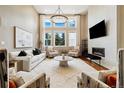 Bright living room featuring high ceilings, large windows, modern fireplace, and contemporary furnishings at 4193 W 99Th Ct, Westminster, CO 80031