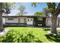 Charming single-story home featuring a large front yard and beautifully landscaped greenery at 4545 S Lipan Ct, Englewood, CO 80110