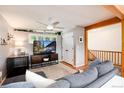 Cozy living room with a ceiling fan, neutral walls, and a view of the staircase at 4545 S Lipan Ct, Englewood, CO 80110