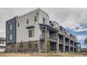 Exterior of new townhomes featuring brick and white siding, private balconies, and professional landscaping at 8321 Mount Kataka St, Littleton, CO 80125