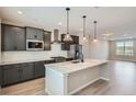 Modern kitchen featuring gray cabinets, stainless steel appliances, a spacious island and pendant lighting at 8321 Mount Kataka St, Littleton, CO 80125