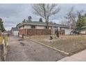 Wide view of property showing the brick facade, long driveway, and trimmed trees at 5738 W Canyon Ave, Littleton, CO 80128