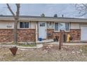 Close up of front yard showcasing a brick facade, rock landscaping, and trimmed trees at 5738 W Canyon Ave, Littleton, CO 80128