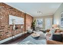 Stylish living room showcasing a decorative brick wall, modern furnishings, and bright natural light at 3956 Kalamath St, Denver, CO 80211